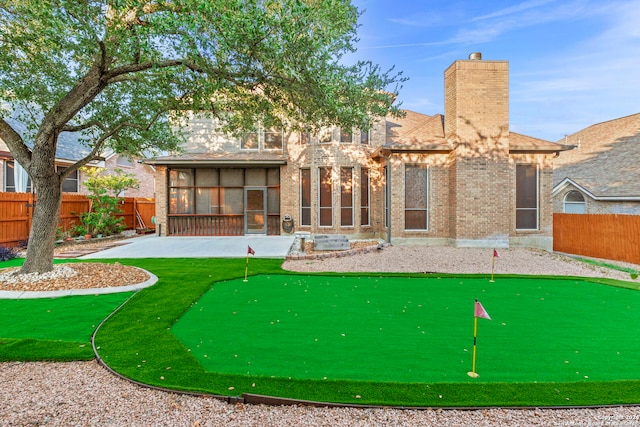 back of property with a sunroom and a patio area