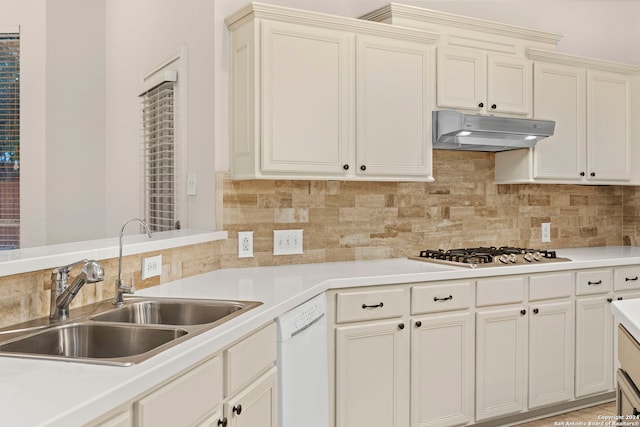 kitchen featuring stainless steel gas cooktop, sink, backsplash, and white dishwasher