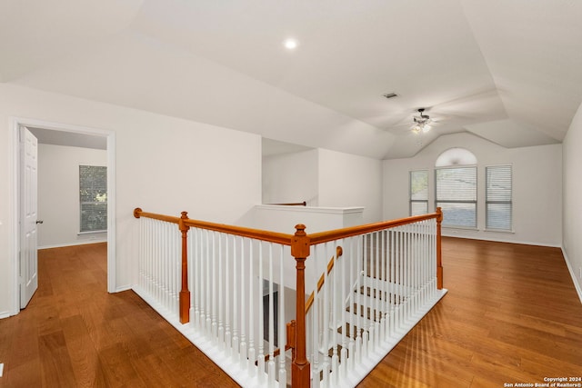 corridor with hardwood / wood-style flooring and lofted ceiling