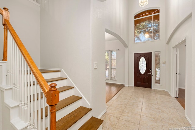 entryway with light tile patterned floors and a high ceiling