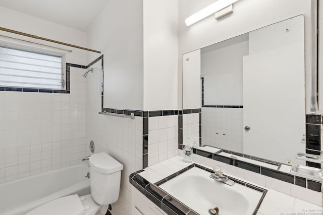 full bathroom featuring tiled shower / bath combo, sink, and toilet