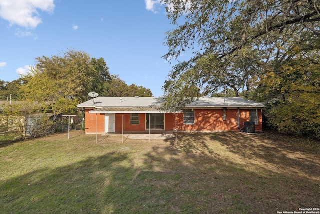 back of property featuring central AC unit, a lawn, and a patio area