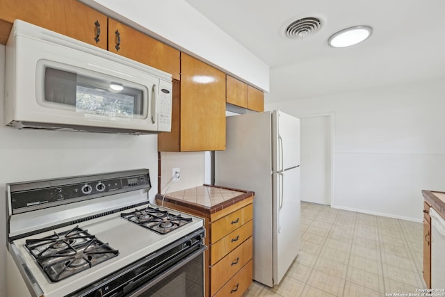 kitchen with white appliances and tile countertops