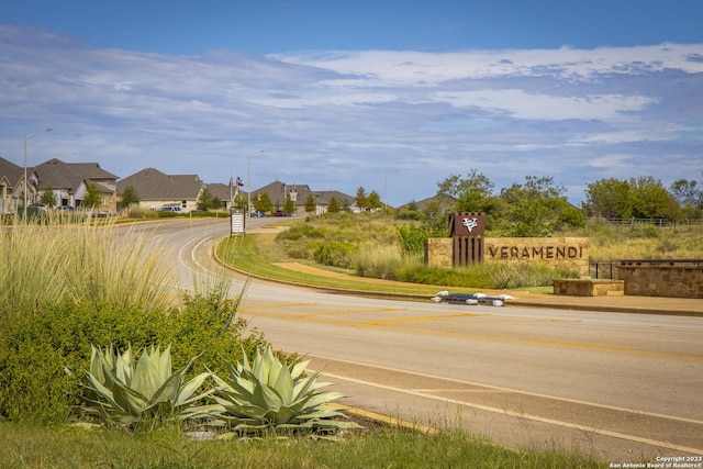 view of road with street lights, curbs, and a residential view