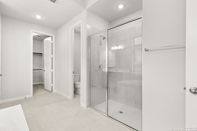 full bath with visible vents, a spacious closet, toilet, a stall shower, and baseboards