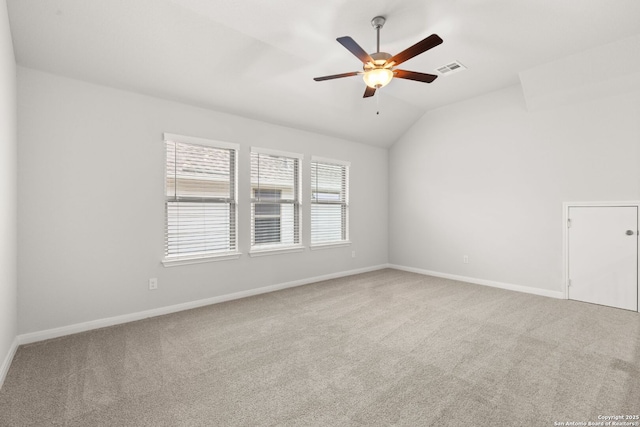 spare room with lofted ceiling, carpet, visible vents, and baseboards