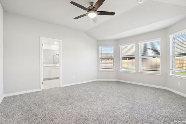 carpeted empty room featuring plenty of natural light, lofted ceiling, and ceiling fan