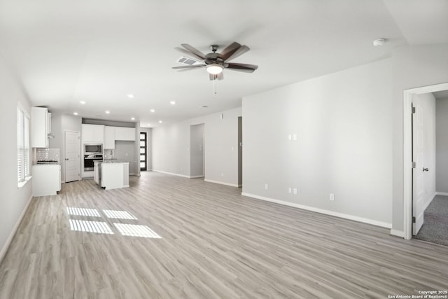 unfurnished living room featuring light hardwood / wood-style flooring and ceiling fan