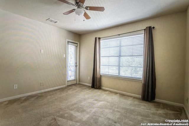 carpeted empty room with a textured ceiling and ceiling fan