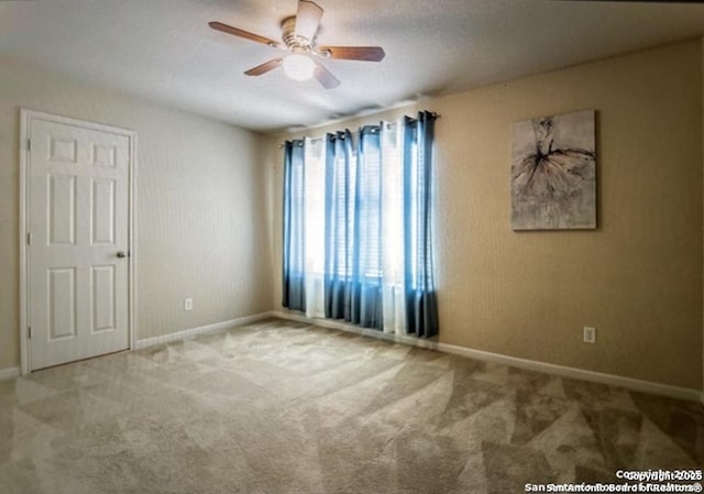 unfurnished room featuring light colored carpet and ceiling fan