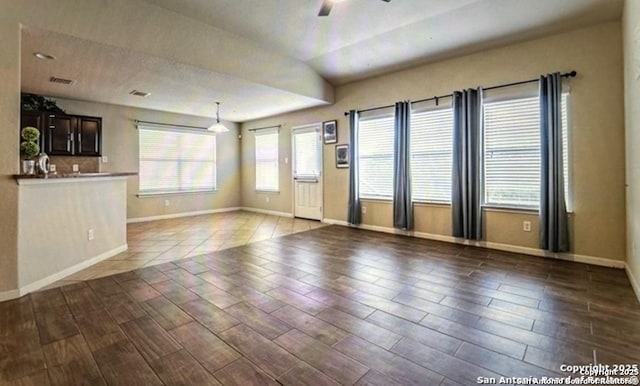 unfurnished living room with ceiling fan, lofted ceiling, and plenty of natural light