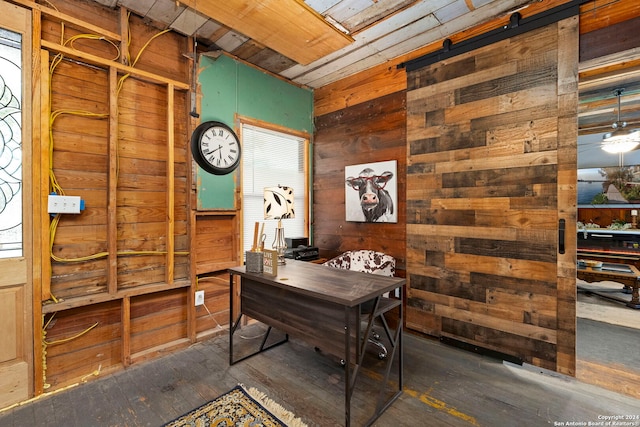 home office with a barn door, wood ceiling, dark hardwood / wood-style flooring, and wood walls