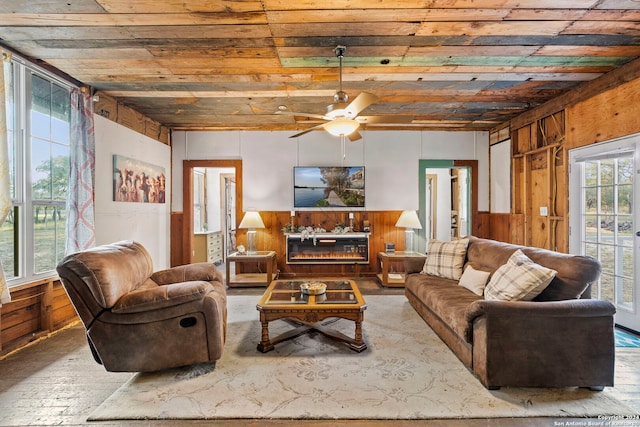 living room featuring wood ceiling, a wealth of natural light, and wood walls