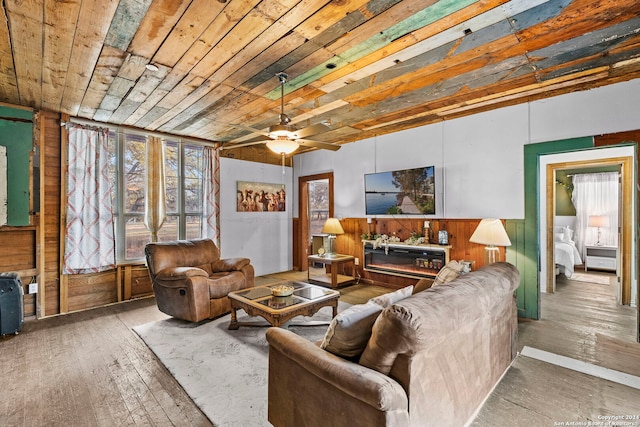 living room featuring a healthy amount of sunlight, hardwood / wood-style floors, wood ceiling, and wood walls