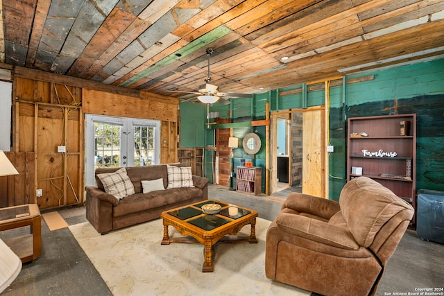 living room with french doors, ceiling fan, and concrete flooring