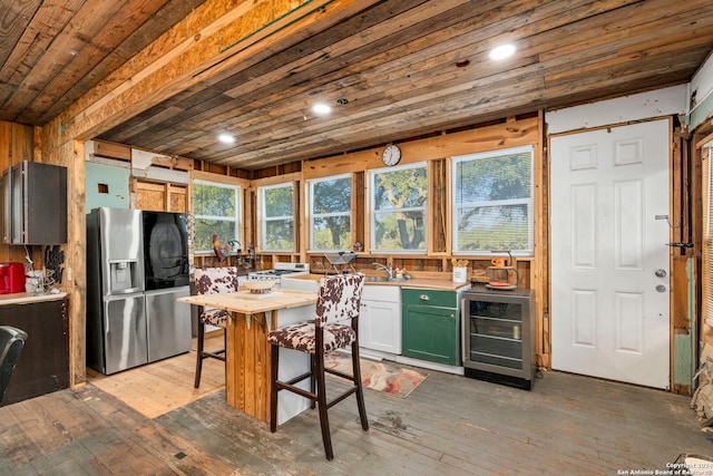 kitchen featuring hardwood / wood-style flooring, a healthy amount of sunlight, wine cooler, and stainless steel fridge