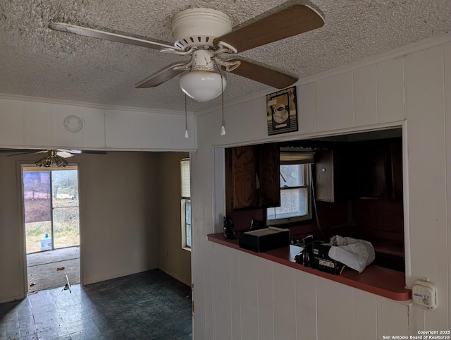 kitchen featuring white cabinets, a textured ceiling, ceiling fan, and wood walls