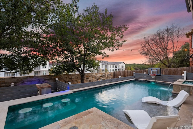 pool at dusk with pool water feature