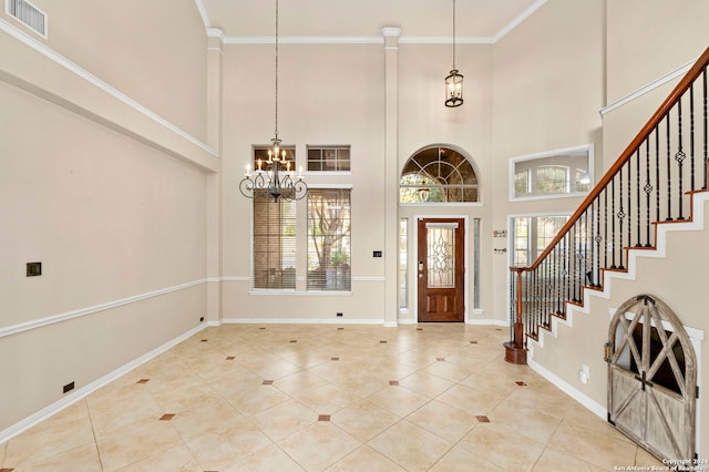 entryway featuring light tile patterned floors, crown molding, a chandelier, and a towering ceiling