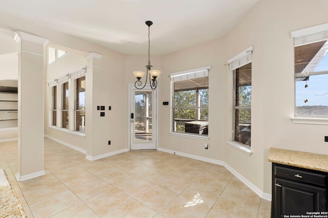 unfurnished dining area featuring light tile patterned floors and a notable chandelier