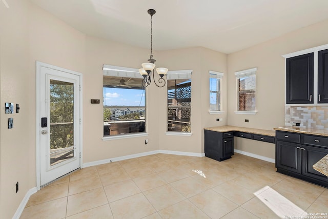 kitchen featuring hanging light fixtures, tasteful backsplash, light tile patterned floors, and a notable chandelier