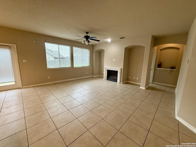 unfurnished living room featuring ceiling fan, a textured ceiling, and light tile patterned floors