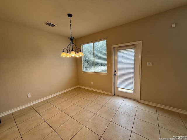 unfurnished dining area featuring light tile patterned flooring and a chandelier