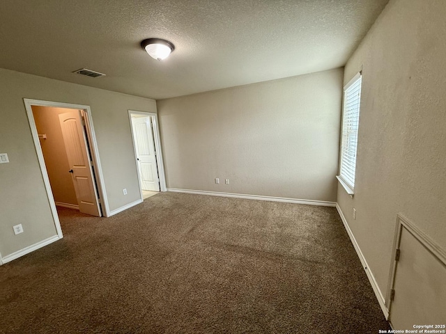 spare room featuring carpet floors and a textured ceiling