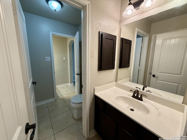 bathroom featuring vanity, tile patterned floors, a textured ceiling, and toilet