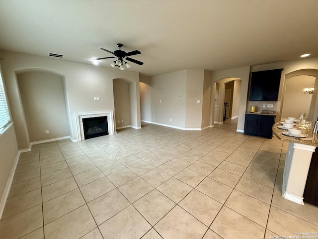 unfurnished living room featuring ceiling fan and light tile patterned flooring