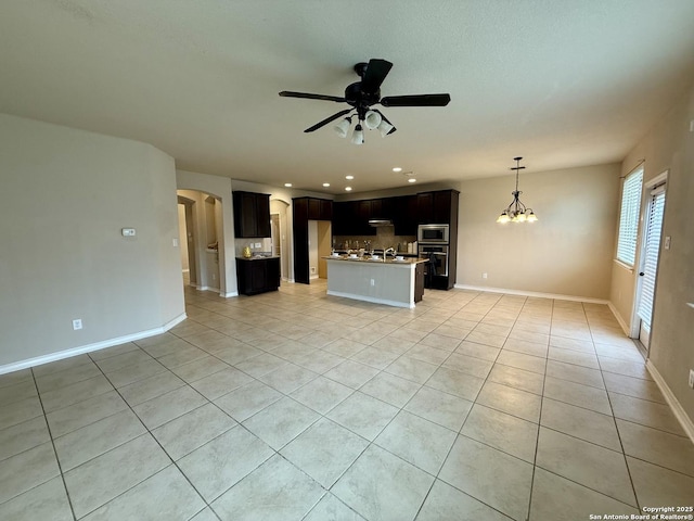 unfurnished living room featuring ceiling fan with notable chandelier and light tile patterned floors