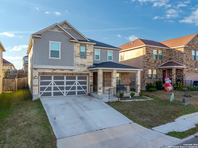 view of front facade featuring a garage, a front yard, and covered porch