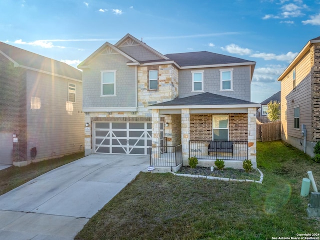 view of front of home with a garage, a front yard, and covered porch