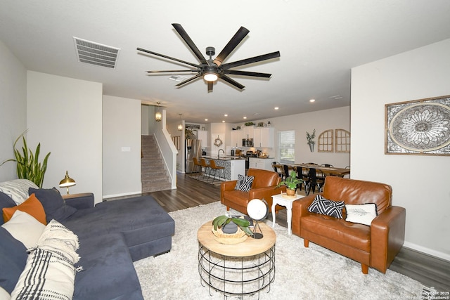 living room featuring sink, dark hardwood / wood-style floors, and ceiling fan