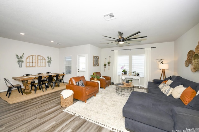 living room featuring light hardwood / wood-style flooring and ceiling fan