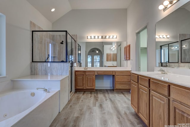 bathroom featuring vanity, hardwood / wood-style flooring, vaulted ceiling, and independent shower and bath