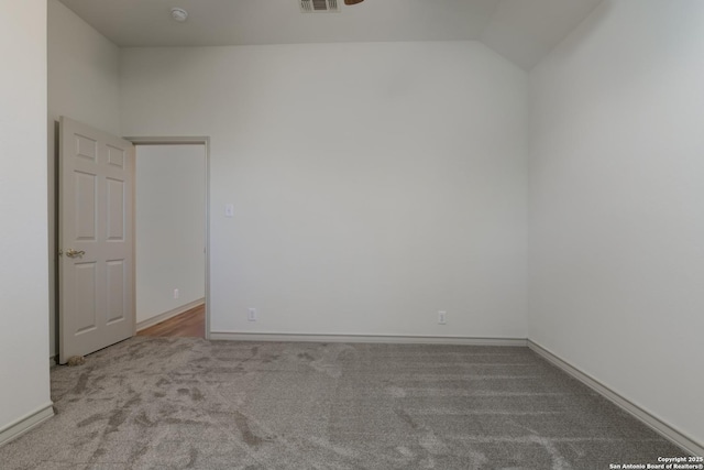 spare room with vaulted ceiling and carpet flooring