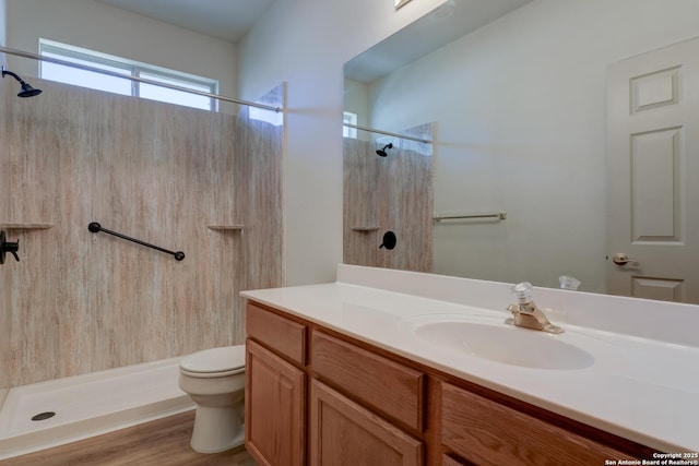 bathroom featuring vanity, hardwood / wood-style floors, a shower, and toilet