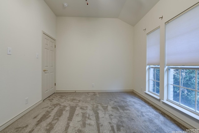 empty room featuring vaulted ceiling and light carpet