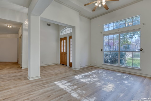 unfurnished room with ornamental molding, light hardwood / wood-style floors, ceiling fan, and a high ceiling