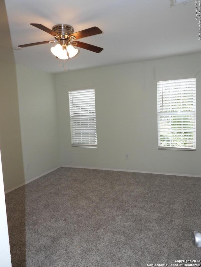 carpeted spare room featuring ceiling fan