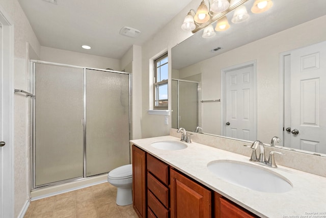 bathroom featuring vanity, toilet, and a shower with door