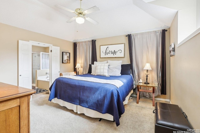 bedroom featuring vaulted ceiling, connected bathroom, light carpet, and ceiling fan