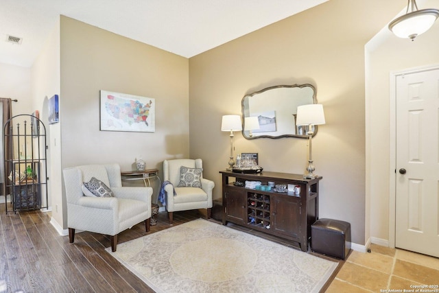 sitting room featuring visible vents, baseboards, and wood finished floors