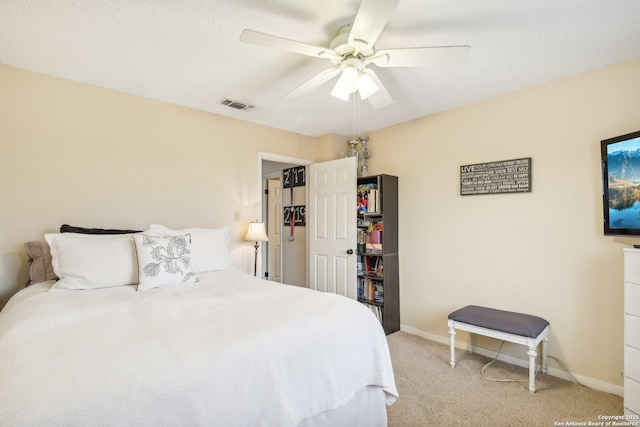 carpeted bedroom featuring a textured ceiling and ceiling fan