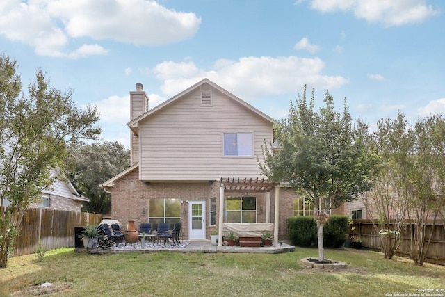 rear view of property featuring a yard, a pergola, and a patio