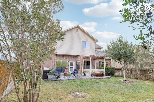 rear view of property featuring a hot tub, a lawn, a patio area, and a pergola