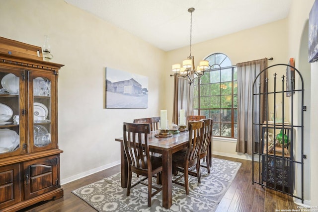 dining space with plenty of natural light, dark wood-type flooring, and a chandelier