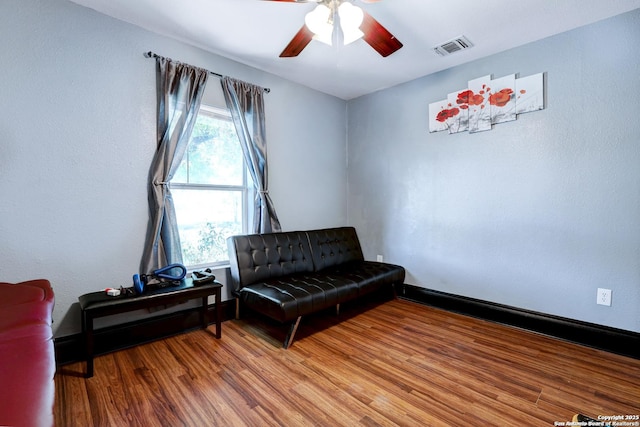 living area with hardwood / wood-style floors and ceiling fan