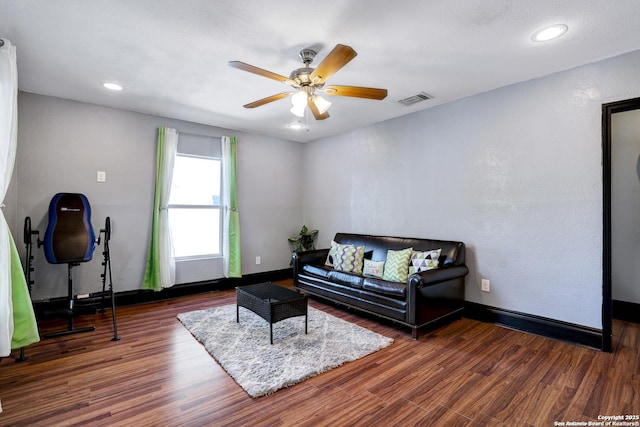 living room with dark hardwood / wood-style floors and ceiling fan